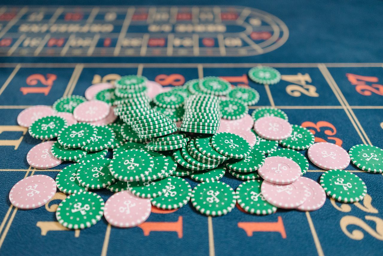 why-choose-us-01 Close-up of a roulette table with a pile of green and pink poker chips.